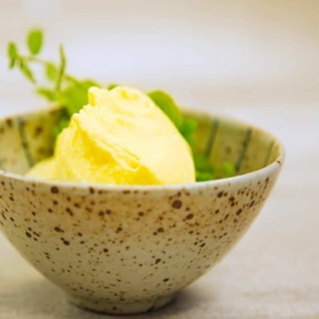 Mangoeis wird in einer Kokosschale serviert