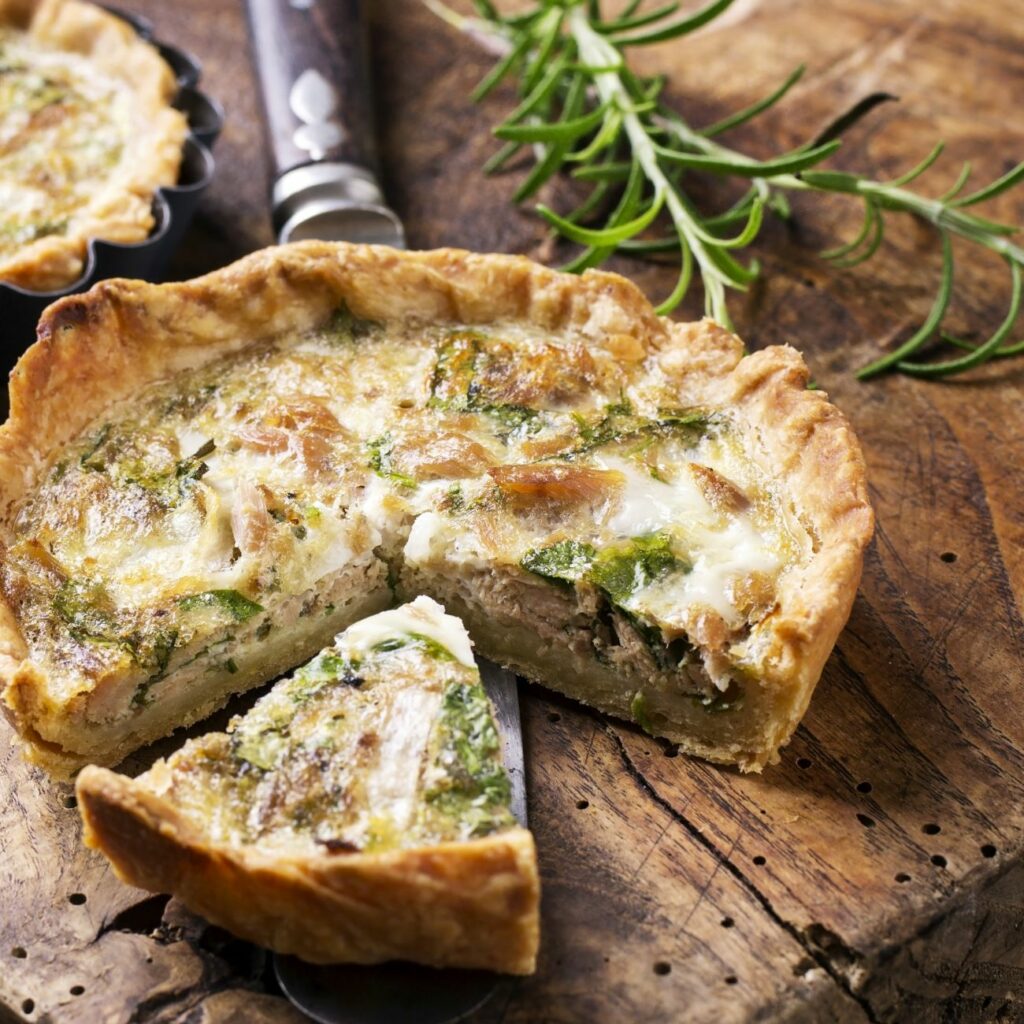 Quiche z nadzieniem z tuńczyka i szpinaku podajemy pokrojony na porcje.