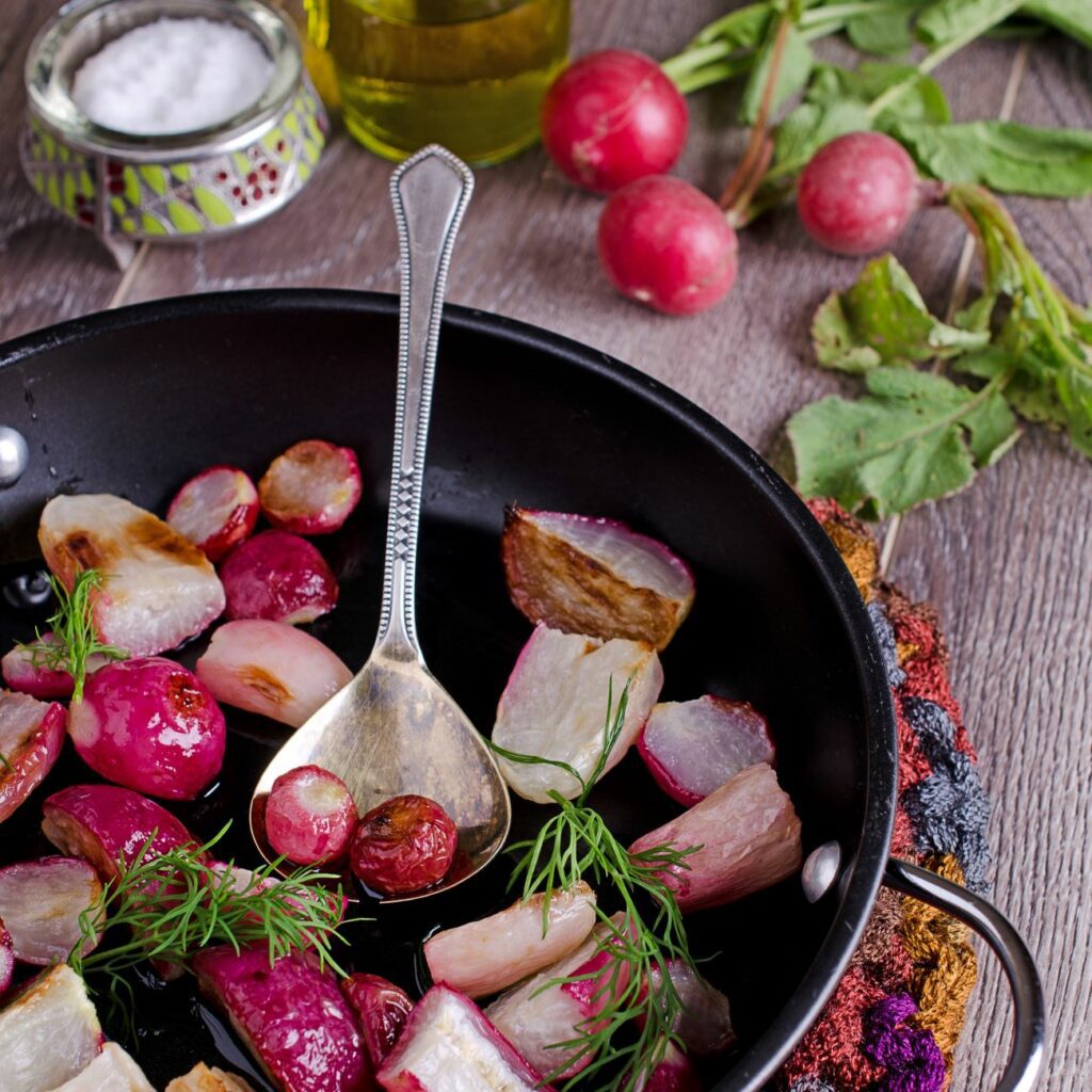 Rzodkiewki z cebulą i czosnkiem z piekarnika serwuje się w formie do zapiekania.