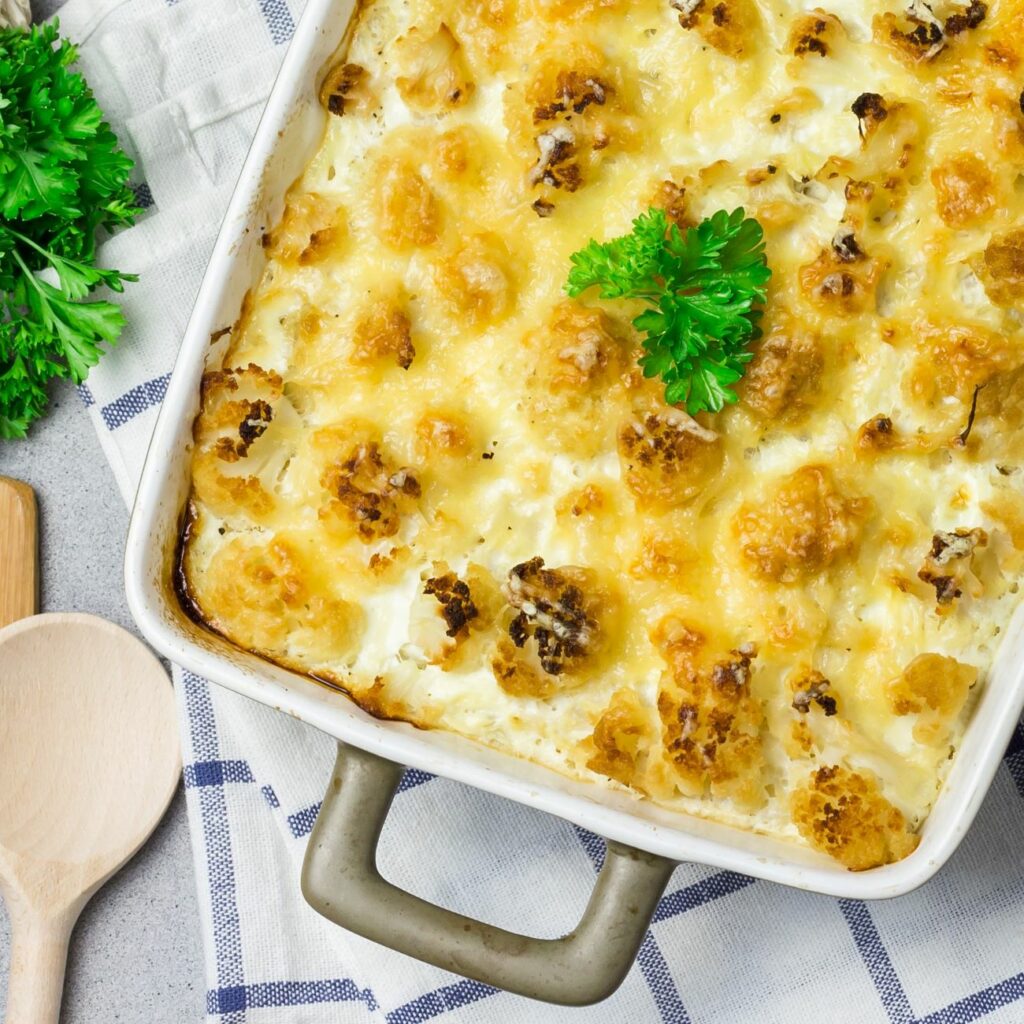 Zapiekanka z kalafiora z brokułami i porem pokazana z góry w naczyniu żaroodpornym