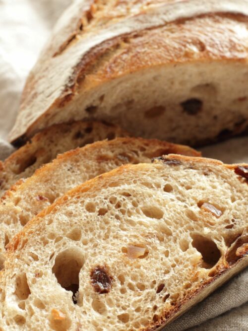 Chleb ziemniaczany z boczkiem pokazany jest w trakcie krojenia