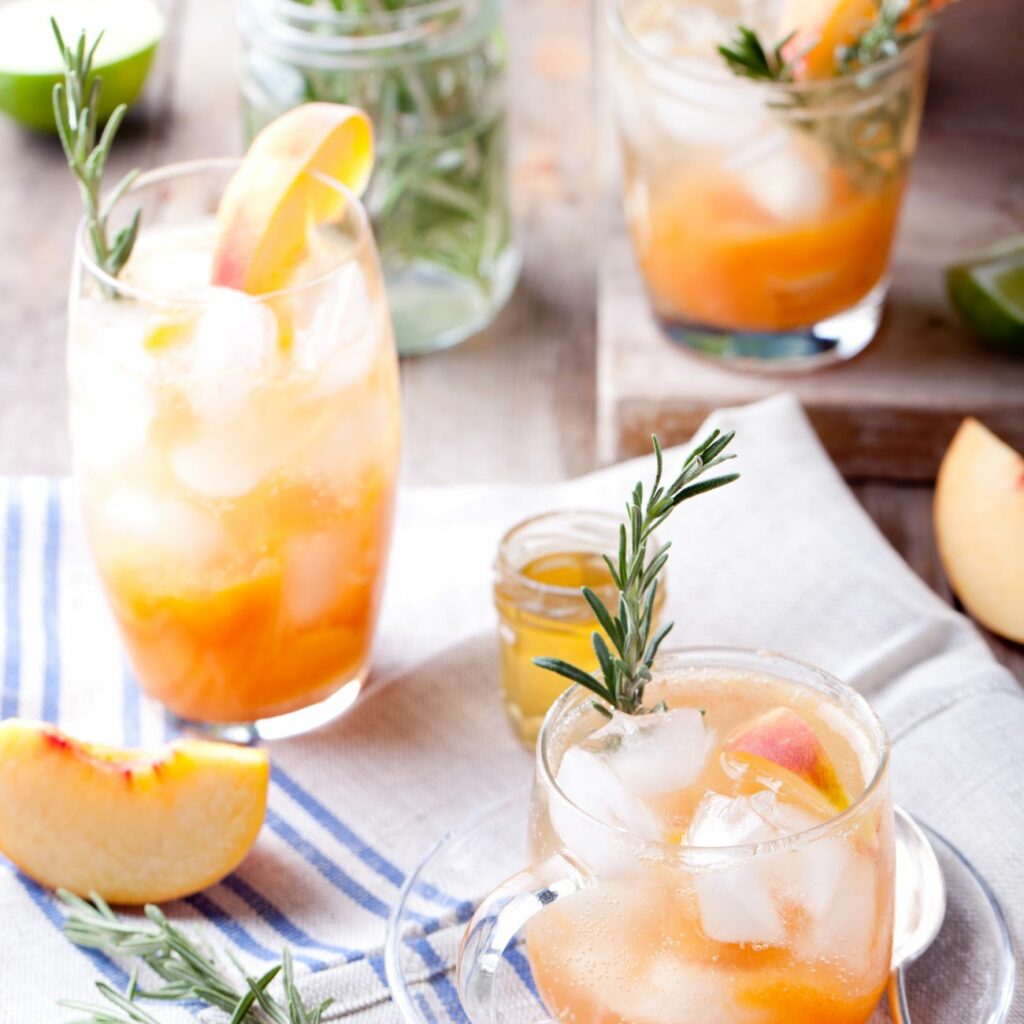 Nektarinen-Limonade wir in Gläsern mit Rosmarin serviert.