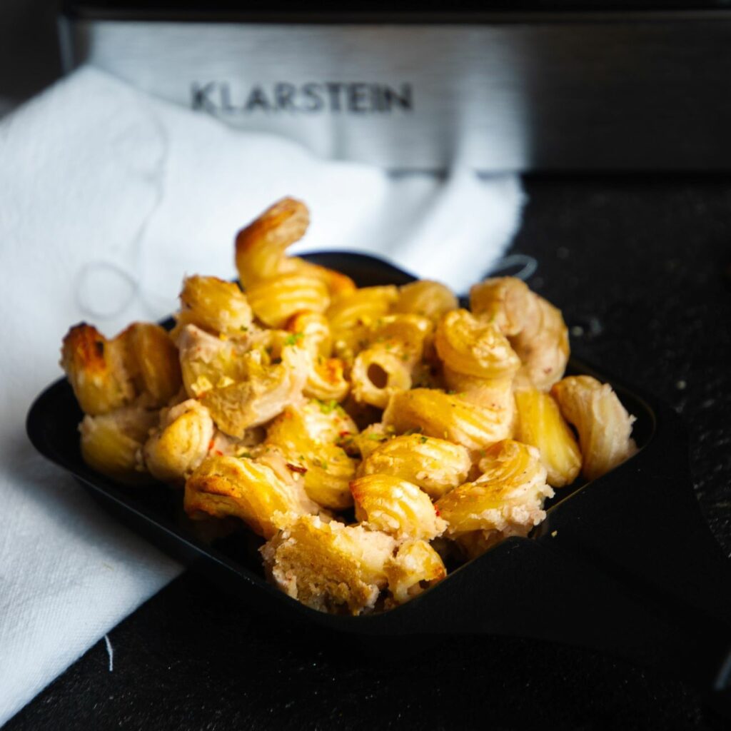 Raclette Mac and Cheese wird nah im Pfännchen gezeigt.