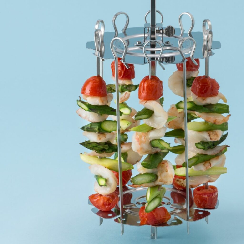 Scampi-Spieße aus der Heißluftfritteuse werden auf dem Drehspießrotator gezeigt.