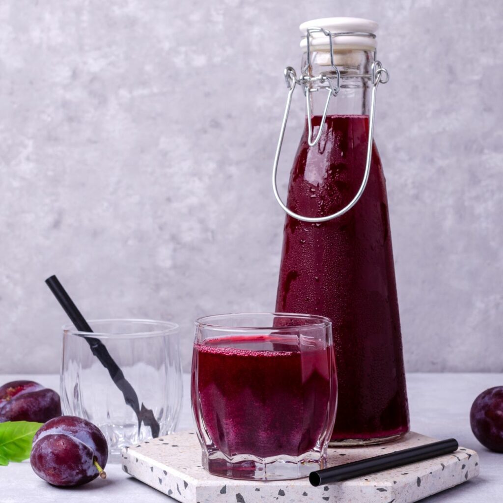 Zwetschgen-Cocktail wird in einem Glas und einer Flasche gezeigt