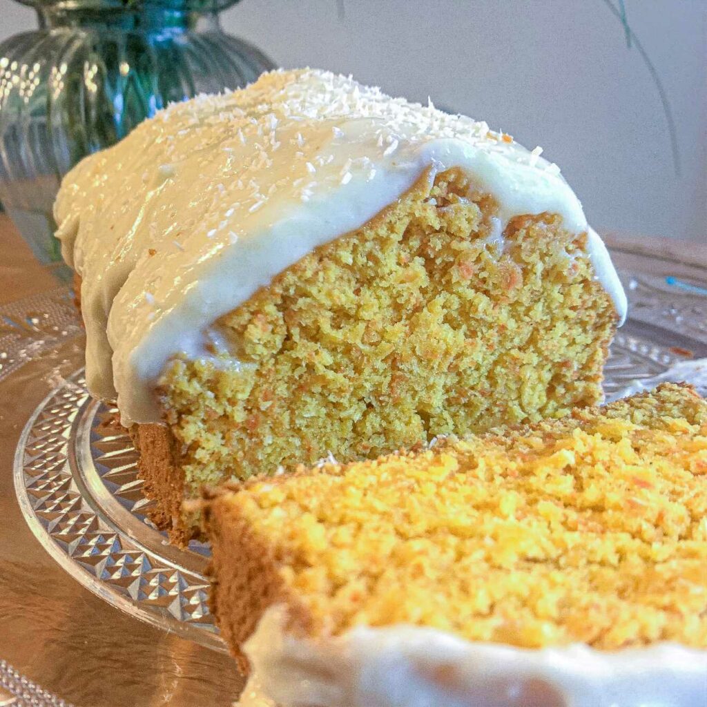 Ciasto marchewkowe z lukrem z serka prezentowane jest po pokrojeniu.