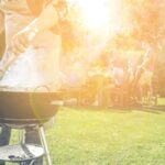 Grill-Tipps: Mann steht am Grill und grillt für seine Freunde