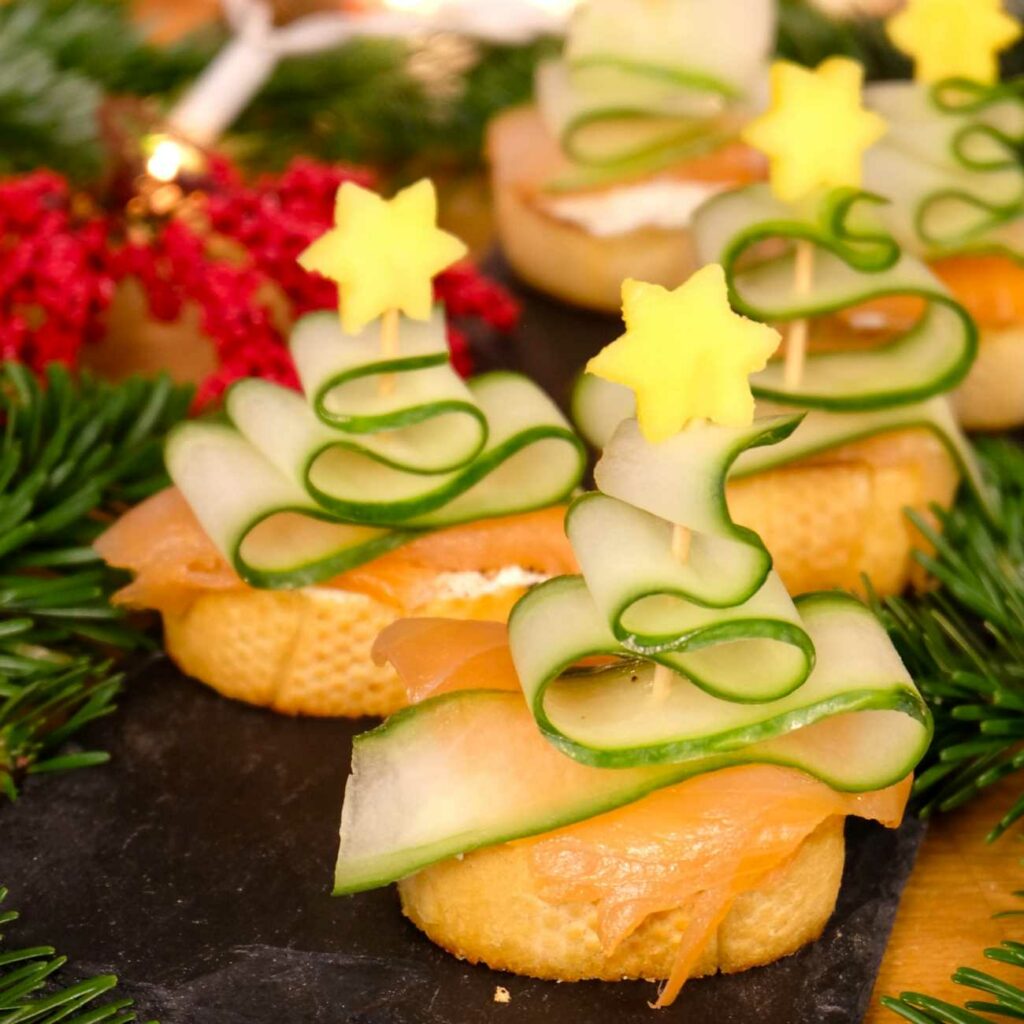 Lachs-Crostini werden auf einer Schiefernplatte mit weihnachtlicher Deko gezeigt.