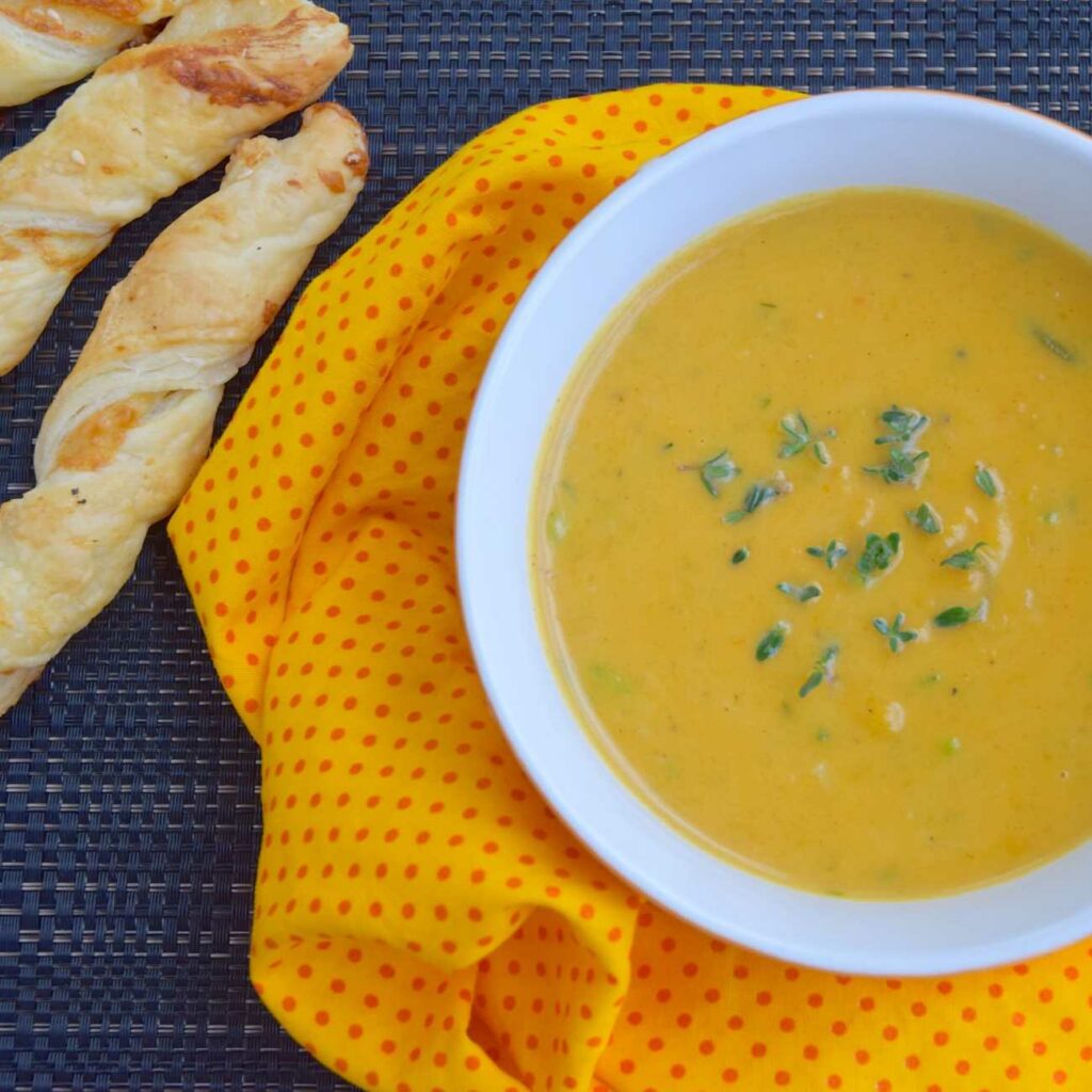 Zupa ziemniaczana curry podawana jest z ziołami na ściereczce z paluszkami chlebowymi.