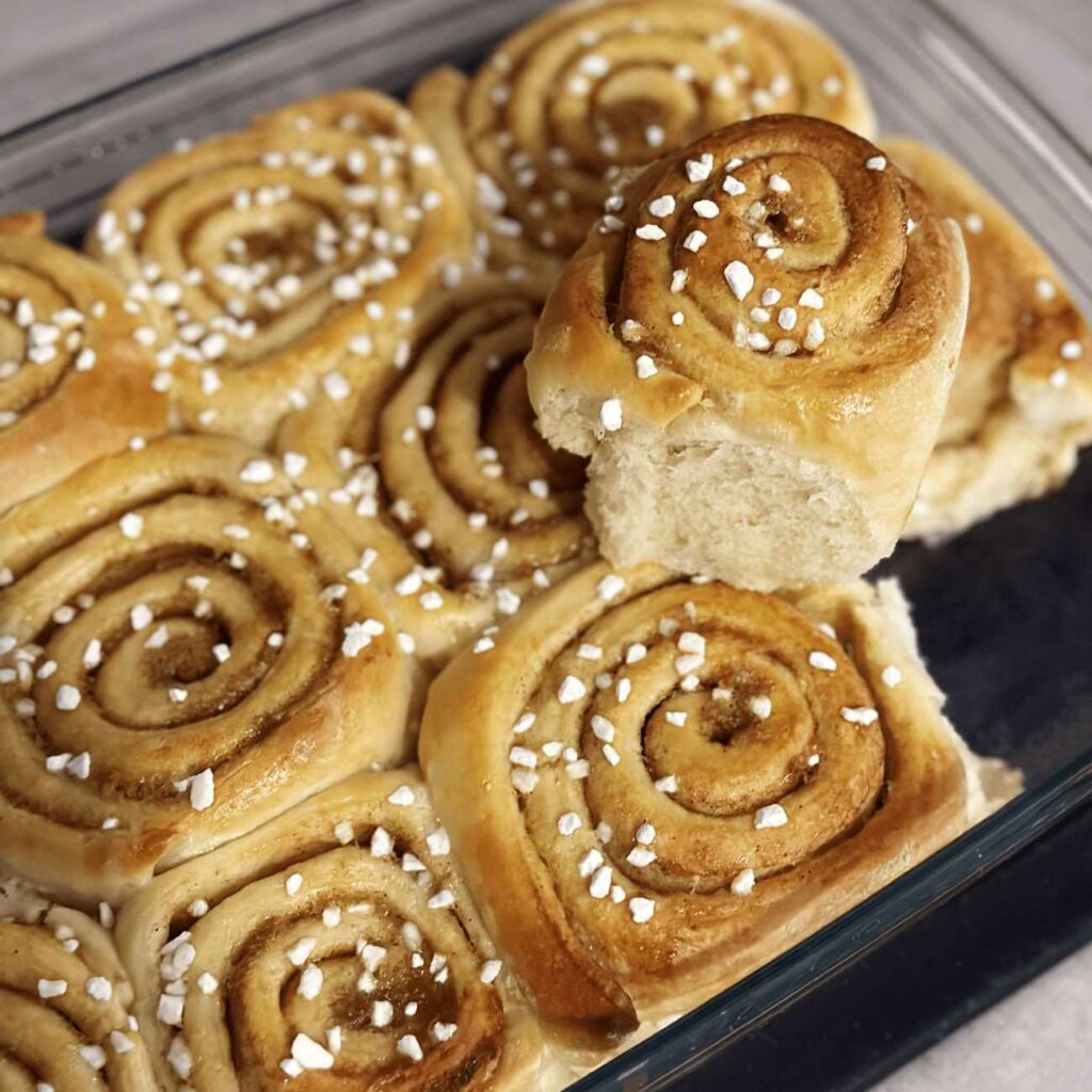 Zimtschnecken werden aus der Auflaufform genommen.