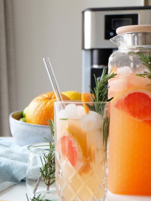 Grapefruit Mocktail wird in der Karaffe und einem Glas präsentiert.