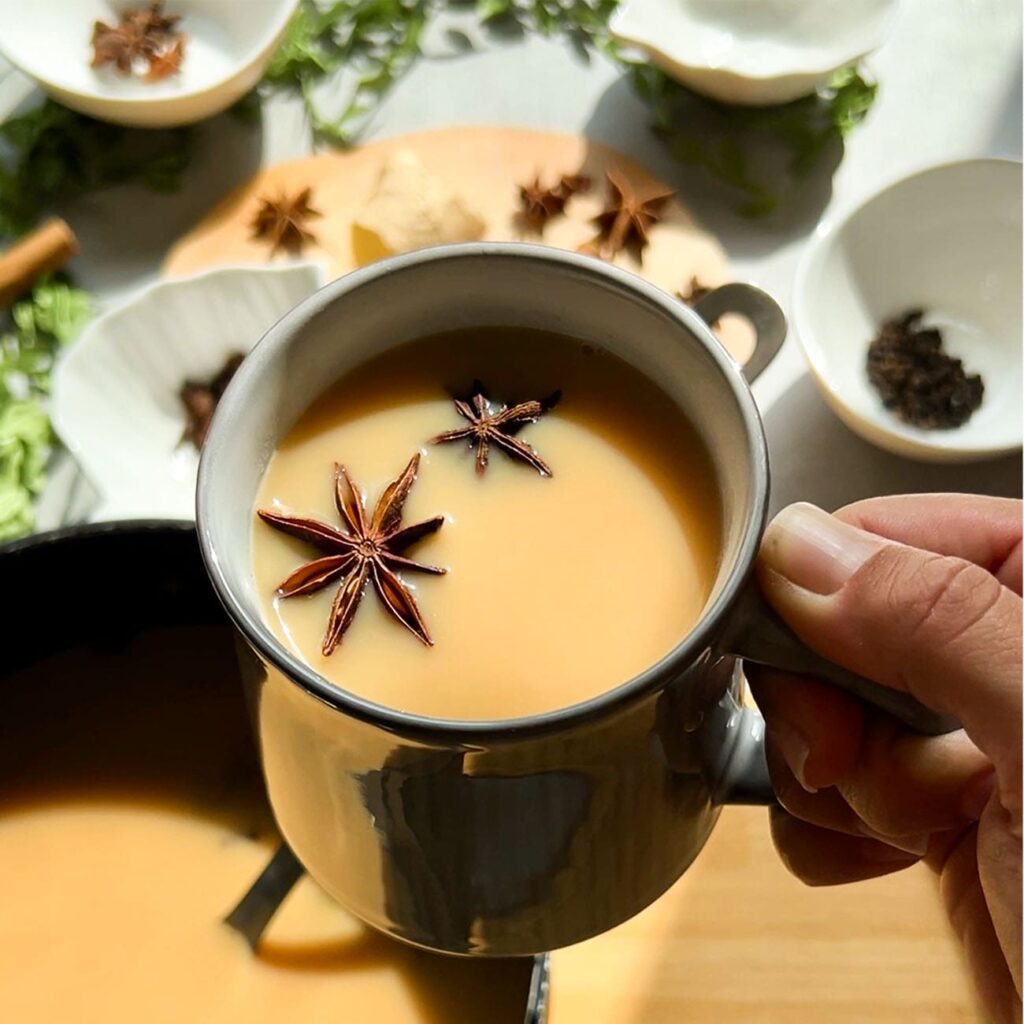 Chai Tee wird in einer Tasse mit Gewürzen im Sonnenlicht gezeigt.