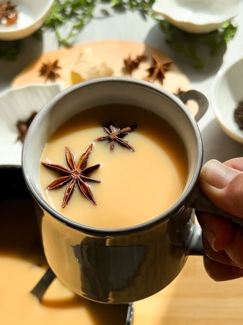 Chai Tee wird in einer Tasse mit Gewürzen im Sonnenlicht gezeigt.